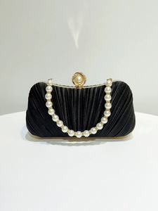 Detail of black pleated satin evening bag with pearl ring clasp and beaded handle