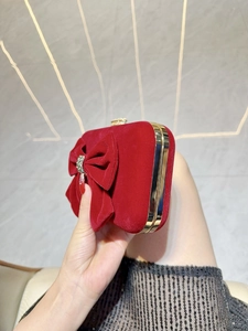 Red velvet evening clutch bag featuring a large bow and crystal center with gold metal frame