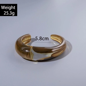 Macro view of amber acrylic bracelet with marble texture showing weight 25.3g and size 5.8cm