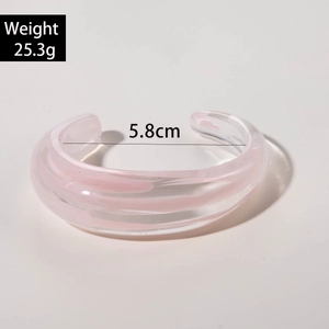 Detail of pink transparent acrylic cuff bracelet showing irregular pleated swirl texture