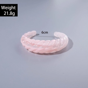 Detail view of pink acrylic open bangle with 6cm inner diameter and spiral wavy texture