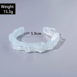 Detail view of light blue acrylic bangle with irregular texture and 5.9cm inner diameter