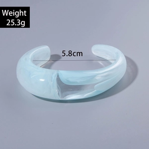 Detail view of light blue acrylic cuff bracelet with marble texture and dimensions