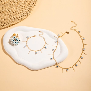 Detail of bohemian evil eye jewelry set featuring blue beads and gold tassel accents