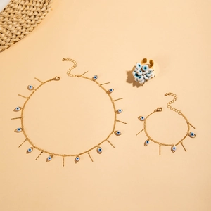 Close-up of golden Evil Eye jewelry set featuring necklace bracelet and ring