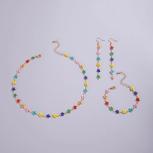 Close-up of colorful star-shaped jewelry set with gold necklace, bracelet, and earrings