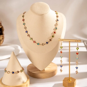 Detailed set of golden jewelry featuring colorful heart-shaped gems with long tassels