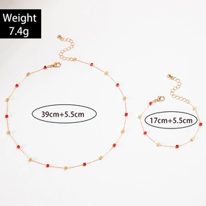 Detail view of gold tassel necklace and bracelet set with red square charms and dimensions