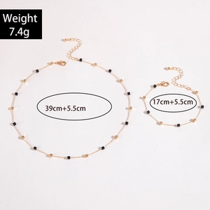 Detail of necklace and bracelet set with delicate gold chains and geometric beads