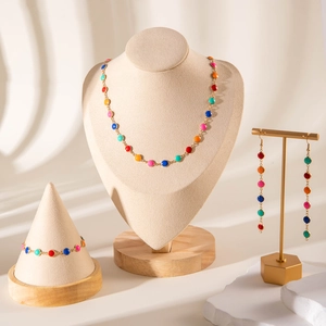 Detail of colorful evil eye jewelry set with gold tassels and multi-color enamel discs