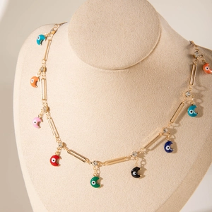 Detail of colorful enamel moon pendants and sparkling crystals on a gold chain necklace
