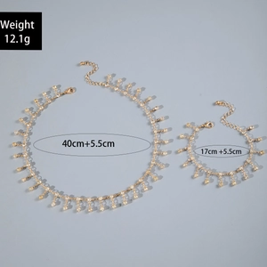 Detail of gold evil eye jewelry set showing necklace and bracelet with dimensions