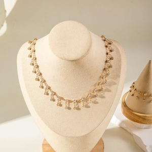 Macro shot of gold fringe necklace and bracelet set with white sparkling rhinestones