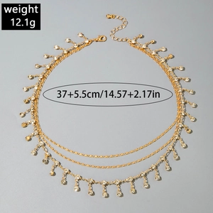 Detailed layered gold necklace with evil eye tassels and sparkling white rhinestones