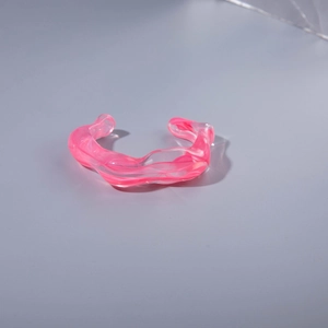 Modern pink and white acrylic open bangle with an irregular wave texture design