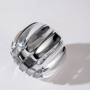 Minimalist spiral silver bangle with thick textured segments on a clean white background