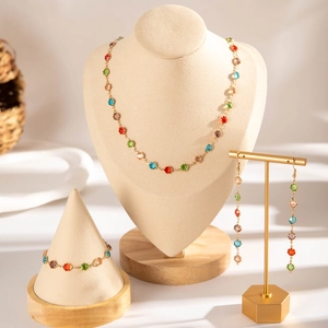 Golden jewelry set with multi-colored gemstones on a necklace, bracelet, and earrings