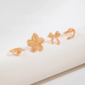 Set of four gold-plated alloy rings featuring a floral design and bow knot accents