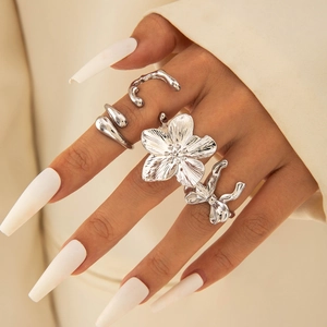 Detail view of silver floral ring set with bow and liquid metal bands on hand