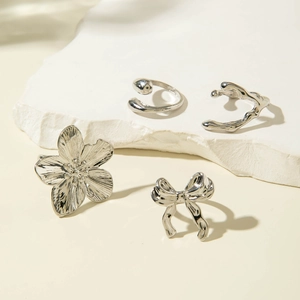Detailed close-up of a 4-piece silver alloy ring set featuring flower and bow designs