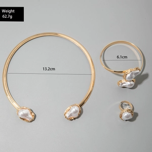 Detailed view of Baroque pearl jewelry set featuring a gold necklace, bracelet and ring