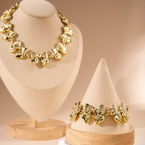 Set di gioielli con collana e bracciale a fiocco in oro lucido su espositore