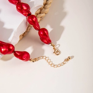 Irregular red bead necklace with gold-plated star charm and lobster clasp closure