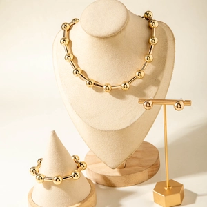 Set di gioielli dorati con collana bracciale e orecchini su eleganti supporti da esposizione