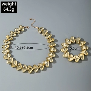 Close-up of golden chunky heart necklace and bracelet set with size and weight specs