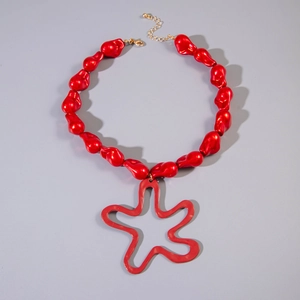 Detailed view of red irregular pearl beads with gold star pendant and lobster clasp