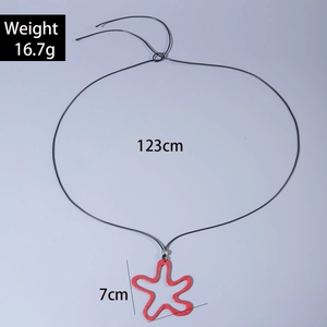 Detail shot of a 7cm red wavy star alloy pendant on a 123cm long black cord necklace