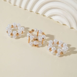 Detailed view of three pearl and gold alloy rings with intricate woven beadwork design