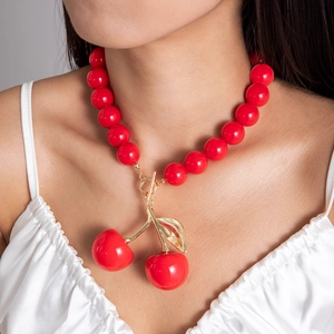 Detail of red acrylic cherry pendant necklace with gold leaves and OT toggle clasp