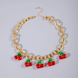 Detail of gold chain necklace with red cherry pendants and lobster clasp closure