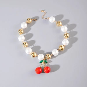 Detail of beaded necklace with large white pearls, gold beads and a red cherry pendant