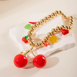 Detail of beaded necklace with vibrant red cherry charms and colorful star accents