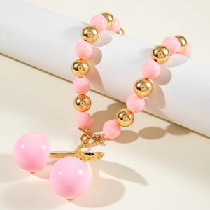Detailed shot of acrylic cherry pendant necklace with pink beads and golden toggle clasp