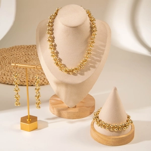 Detailed set of gold bead necklace, bracelet and earrings displayed on luxury stands