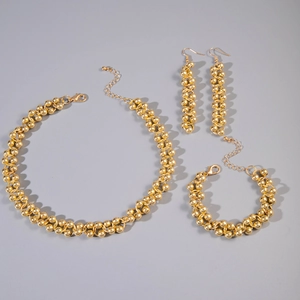 Detail of gold-plated geometric beaded jewelry set including necklace and bracelet
