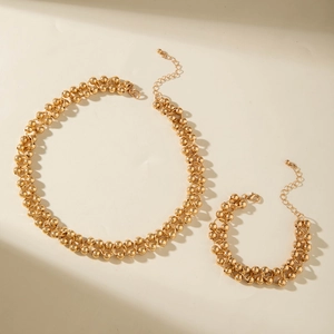 Macro view of gold beaded necklace and bracelet set with lobster clasp and extender