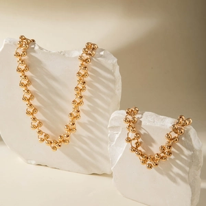 Macro shot of chunky gold CCB bead necklace and bracelet on white stone props