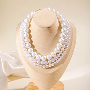 Elegante collana a tre strati di perle sintetiche con perline graduate su busto da studio