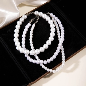 Set di collane di perle multistrato eleganti con tre dimensioni su velluto nero liscio