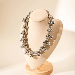Detailed view of glossy silver CCB bead necklace layered on a professional neck display