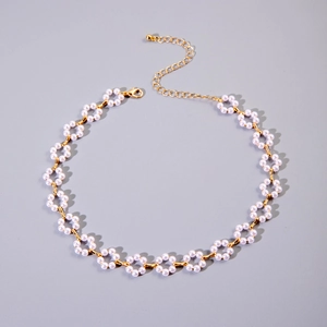 Close-up of pearl beaded floral necklace with gold lobster clasp and extension chain