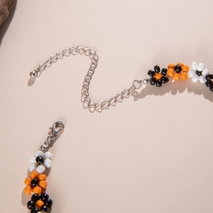 Macro detail of Halloween floral beaded necklace with silver lobster clasp and extension chain