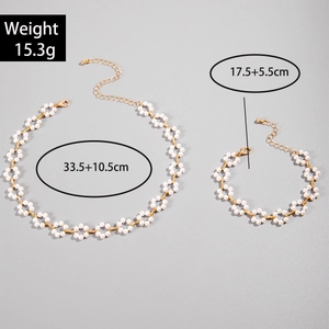 Flat lay of pearl necklace and bracelet set with floral patterns and weight details