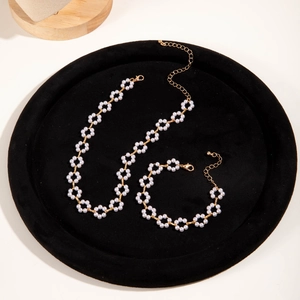 Detail of vintage pearl flower necklace and bracelet set on black velvet tray
