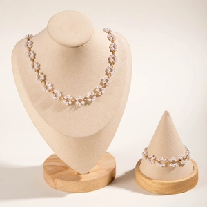 Detail of elegant pearl necklace and bracelet set featuring floral hollow design