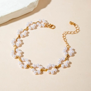 Close-up of a gold pearl floral necklace with intricate flower clusters and lobster clasp